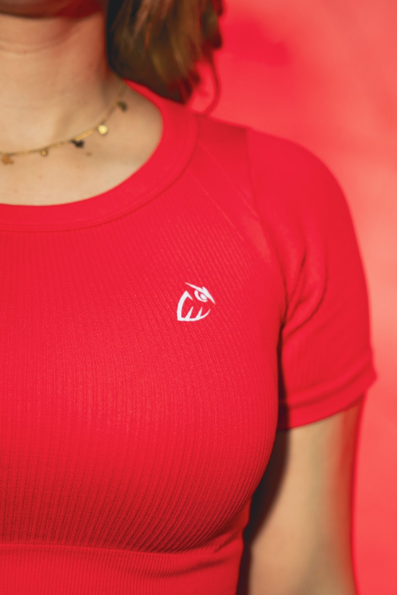 Detalle logo Owluxe y tela acanalada en top deportivo Rubi rojo